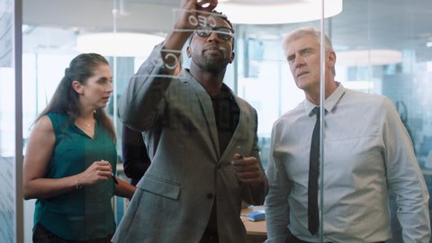 diverse business people using sticky notes african american team leader man brainstorming with colleagues working on solution discussing strategy writing on glass whiteboard in office meeting 4k
