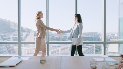 business women shaking hands in boardroom meeting successful corporate partnership deal with handshake colleagues clapping hands welcoming opportunity for cooperation in office 4k