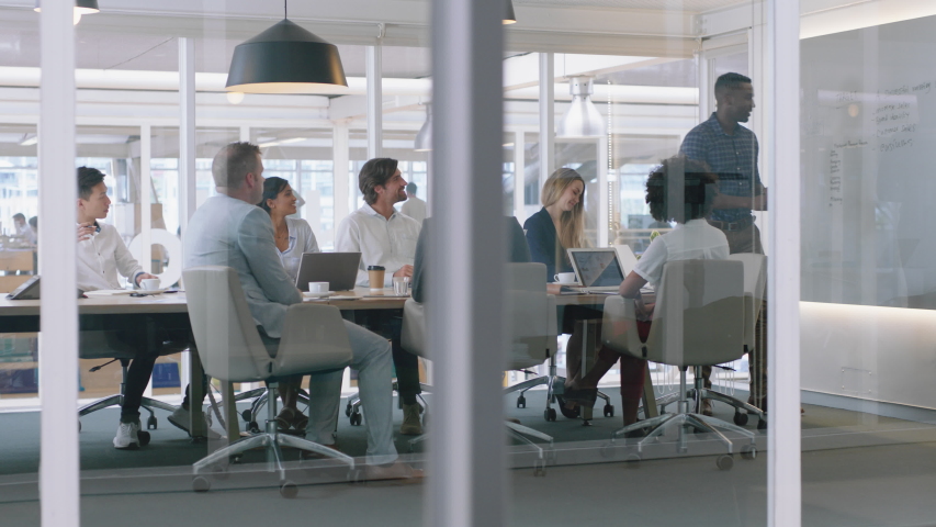 Group of business people meeting in boardroom team leader man presenting ideas on whiteboard discussing strategy with colleagues in office training presentation 4k | Shutterstock HD Video #1034543900