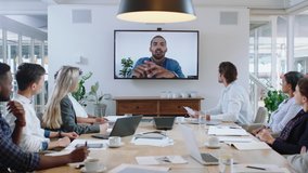 group of business people having conference call meeting in boardroom team leader man chatting to colleagues using online video chat on tv screen discussing ideas in office 4k