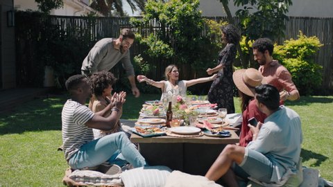 happy friends celebrating garden party lunch having fun chatting sharing healthy food enjoying weekend reunion relaxing on beautiful summer day outdoors 4k