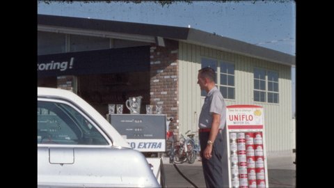 1960s: Gas station attendant stands next to trunk of silver sedan and a display of Uniflo Motor Oil, he pulls the hose from the pump, pumps gas into the sedan.