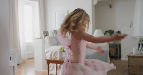 beautiful little girl dancing playfully pretending to be ballerina funny child having fun playing dress up wearing ballet costume with fairy wings at home 4k