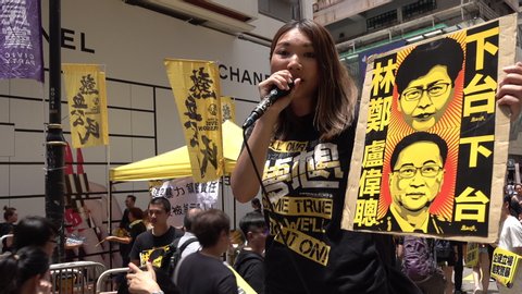 HONG KONG – 1 JULY 2019: Young woman uses microphone to address crowds taking part in anti extradition bill protests in Hong Kong