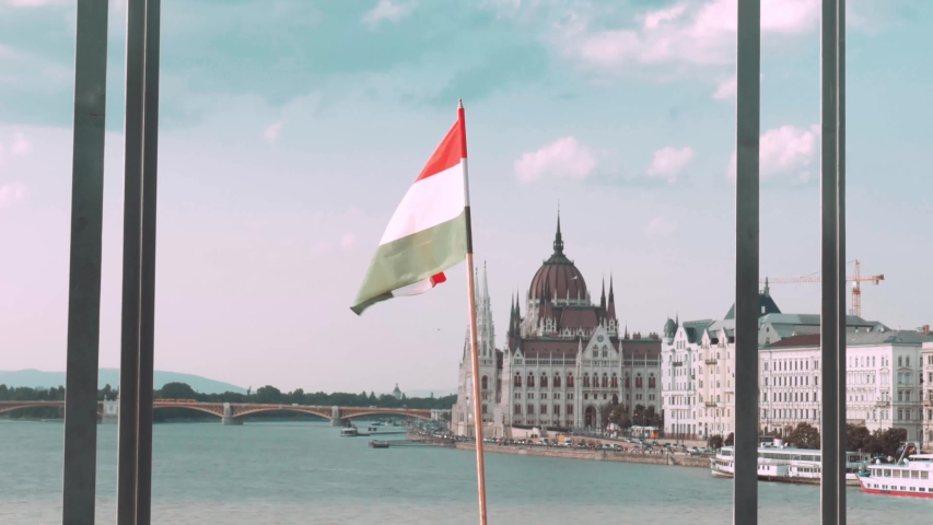 Hungary flag waving in the background of the Parliament building in Budapest