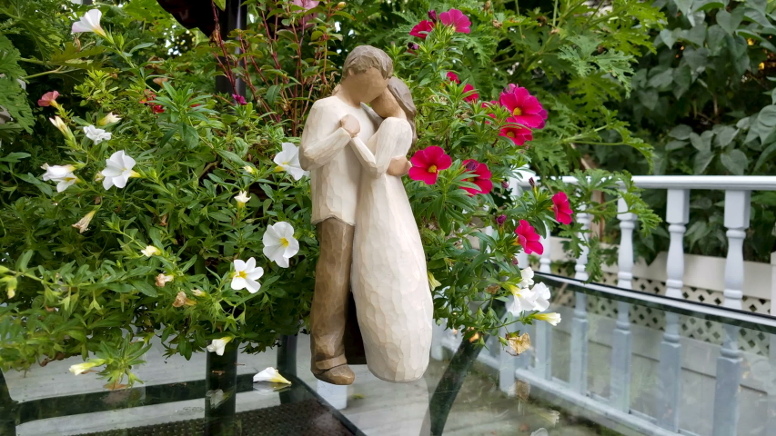 Sculpted hand-painted figures. Beautiful young woman and man are holding each other in the arms of love.