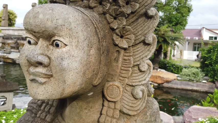 Close up view of an ancient statue at a beautiful garden.