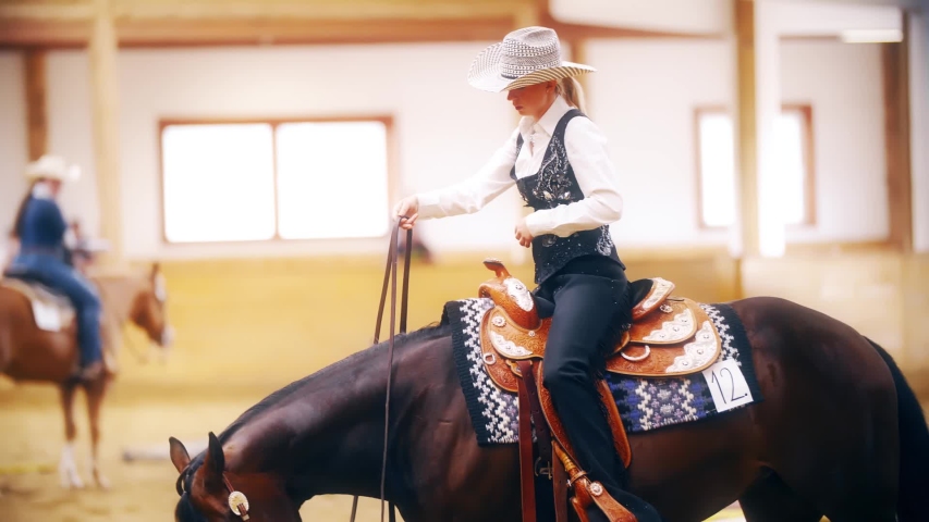 Cowgirl ride horse one-handed in slow motion