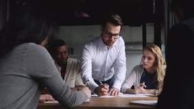 Serious male corporate leader boss analyze financial report data training workers team at briefing table, businessman ceo explaining work plan paperwork to diverse employees group at company meeting - Powered by Shutterstock - Get 15% off with code: PIKWIZARD15