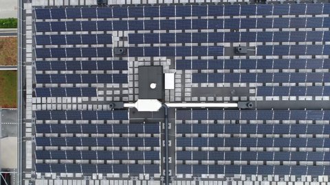 Aerial top down view of just finished modern neighborhood apartment building with solar panels on flat roof providing the residential part with renewable energy from the sun 4k high resolution