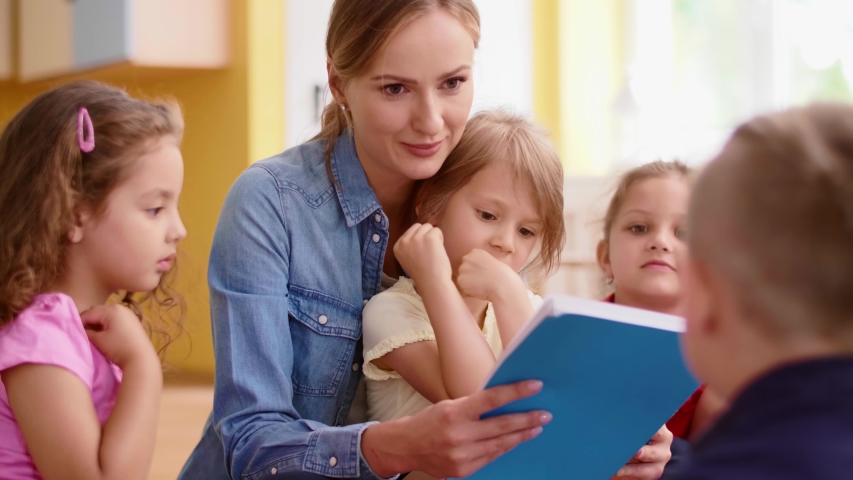 Kids and teacher reading a book together in the preschool Royalty-Free Stock Footage #1034596364