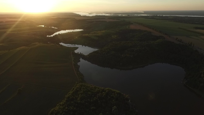 Beautiful landscape from a height. Flying over the river, fields and forests.