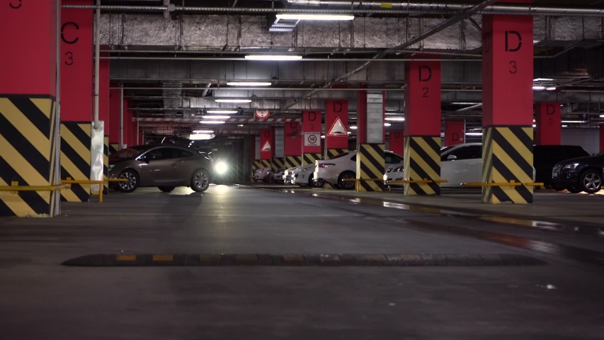 Underground parking of the Shopping Center. Parking garage underground, industrial interior, parking lanes