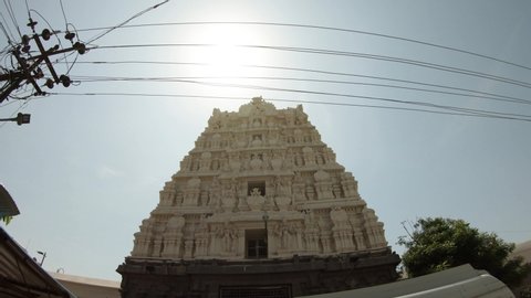 Gopuram monumental entrance tower with sculptural composition to hindu temple Ekambareswarar post with wires sun is shining Kanchipuram Tamil Nadu 