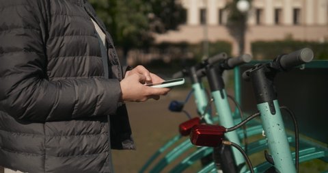 Woman take Electric Kick scooter in sharing parking lot, tourist phone application. New sharing business project started
