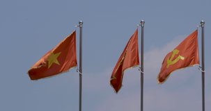 4k Video of National Flags of Vietnam with a Flag of Communist Party of Vietnam or CPV. The National flag is red with a large gold star. The CPV has Hammer and Sickle.