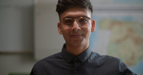 Portrait of young student in classroom wearing funky glasses, smiling and confident