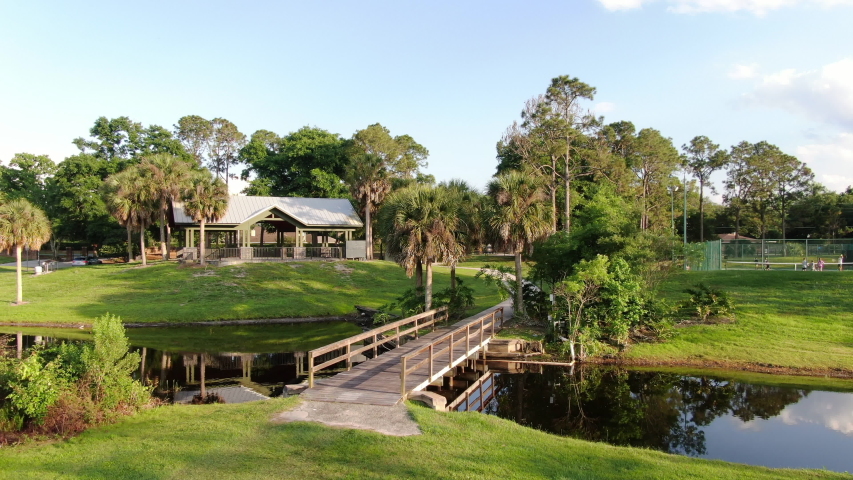 Lakeside Park with a Wooden Bridge over a Stream, with Tennis Courts and Gazebo