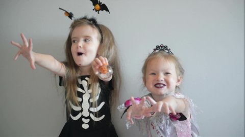 Two Cutie Girls In Halloween Costumes Are Having Fun Together. Funny Costumes. Isolated.