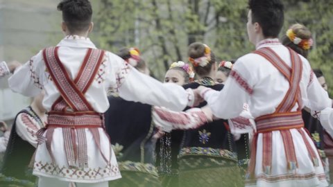 Pitesti/Romania - May 2019: Young people dressed in traditional costumes perform folk Romanian dances on the street