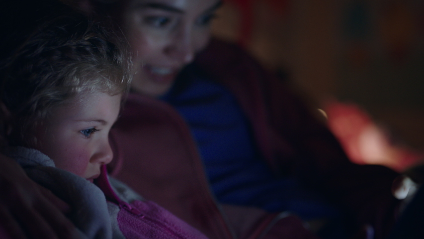 mother and child using tablet computer mom teaching little girl playing games on touchscreen technology having fun before bedtime