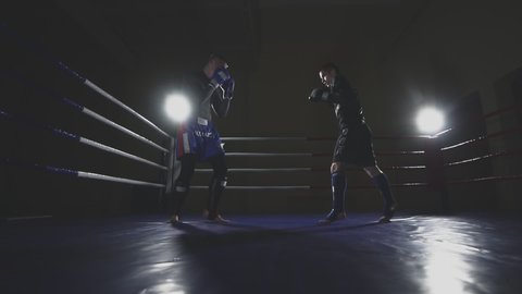 Boxers train before fight in ring. Muay thai fighters sparring in slow motion.