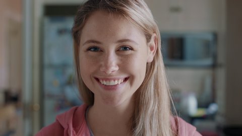 portrait beautiful blonde teenage girl in kitchen at home smiling happy enjoying carefree lifestyle