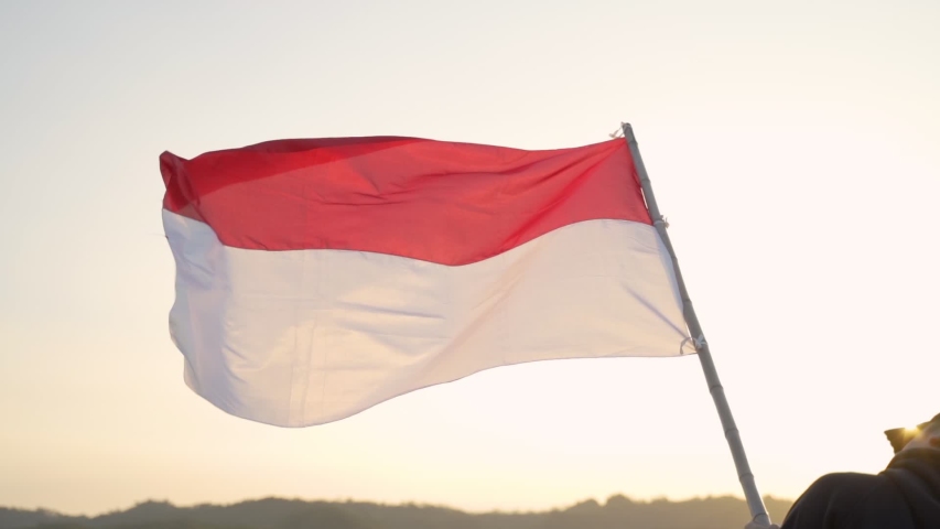 portrait of man on top of the hill in the morning rising indonesian flag celebrating independence day Royalty-Free Stock Footage #1034691275