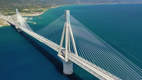 Aerial drone video of world famous cable suspension bridge of Rio - Antirio Harilaos Trikoupis, crossing Corinthian Gulf, mainland Greece to Peloponnese, Patras