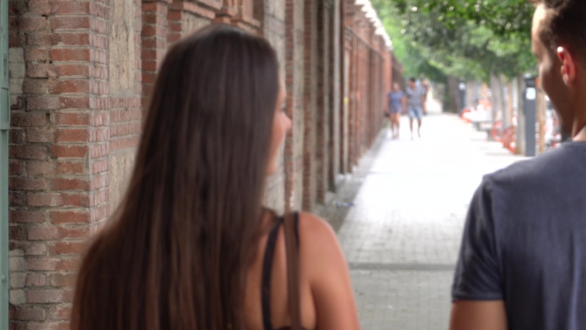 Couple in love young woman and man walk in love in urban area.