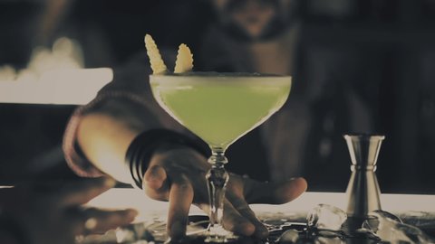 Womans hand takes a cocktail at the bar