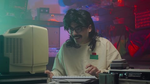 Happy computer nerd in the '80s or '90s using his personal computer. Retro scene with vintage colors and atmosphere.