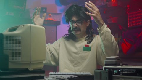 In the '80s or '90s.. A frustrated computer nerd slapping his personal computer and keyboard. Retro scene with vintage colors and atmosphere.