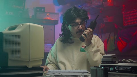 In the '80s or '90s computer nerd using his walkie Talkie. Retro scene with vintage colors and atmosphere.