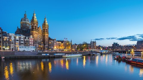 Amsterdam canal and skyline at night with Saint Nicholas Church time lapse in Amsterdam city, Netherlands