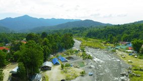 Aerial drone footage of beautiful rural clean river flows over rocks at Melangkap river, Sabah, Malaysia. 