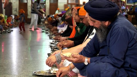 AMRITSAR, INDIA - MARCH 18, 2019: a sikh man eating in golden temple's free food hall at amritsar, india