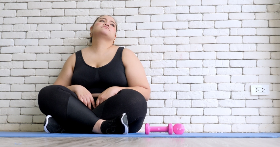 Overweight young woman in sportswear  bored with exercise to lose weight | Shutterstock HD Video #1034728340