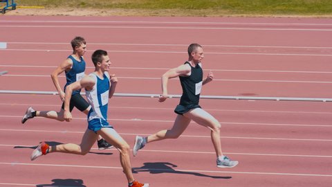 High-angle shot of professional track athletes running on outdoor track arena