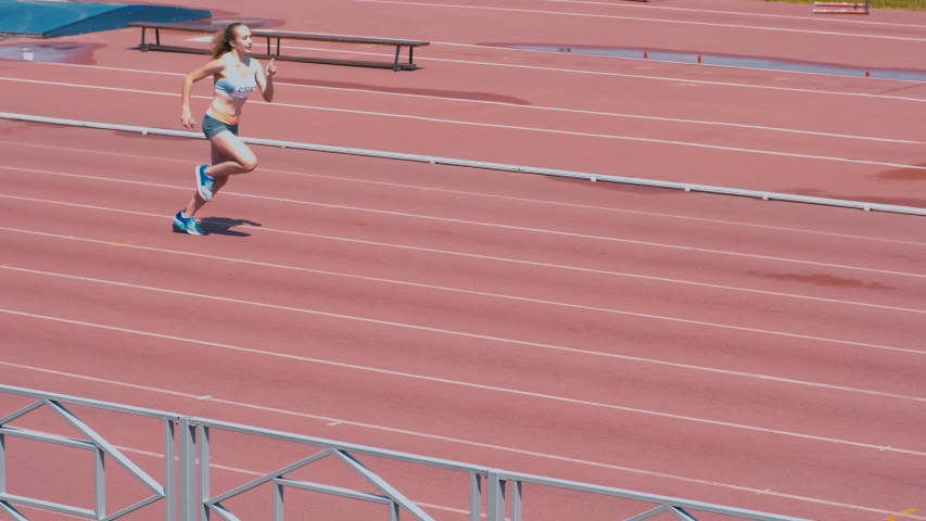 High-angle shot of female sprinter race on outdoor track arena Royalty-Free Stock Footage #1034736653