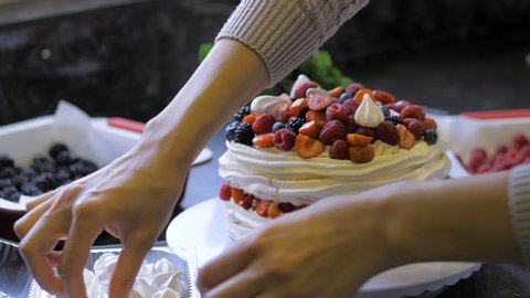 The process of making dessert Anna Pavlova with berries and cream