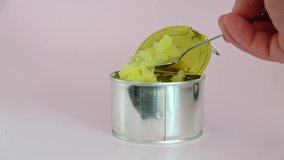 Crushed pineapple in tin can. Hand holding spoon. - Powered by Shutterstock - Get 15% off with code: PIKWIZARD15