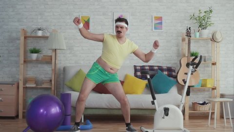 Expressive overweight man with a mustache and glasses funny dancing slow mo