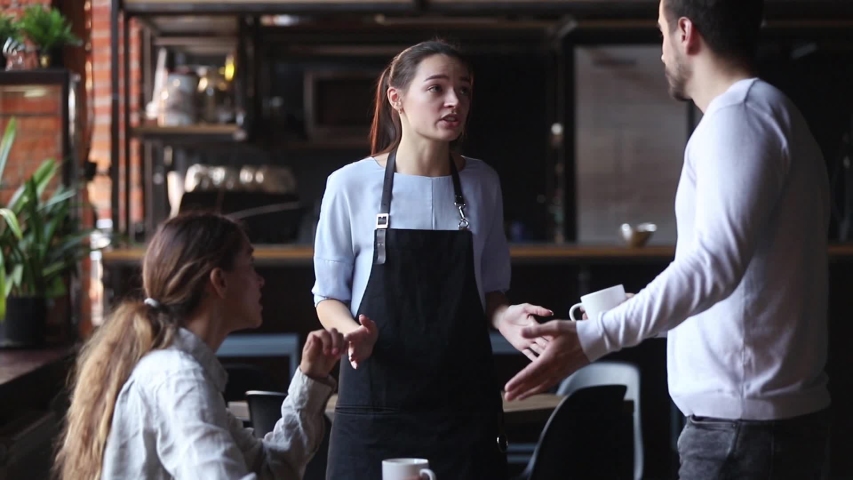 Waitress girl justifies itself to customers clients for mixed up order, low-quality drink cold tea or coffee beverage, hysterical man talks with waiting staff complains about long poor service concept Royalty-Free Stock Footage #1034755988