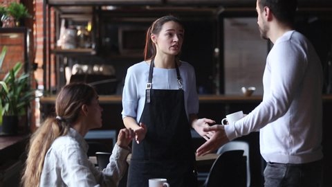 Waitress girl justifies itself to customers clients for mixed up order, low-quality drink cold tea or coffee beverage, hysterical man talks with waiting staff complains about long poor service concept
