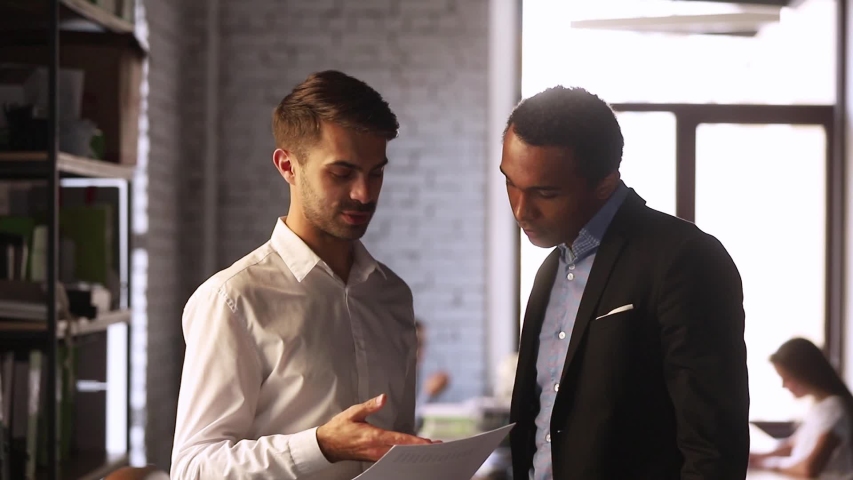 European and black businessmen stands in co-working office discuss document contract details finish talk shaking hands, client and executive manager effective meeting, synergy working together concept Royalty-Free Stock Footage #1034756150