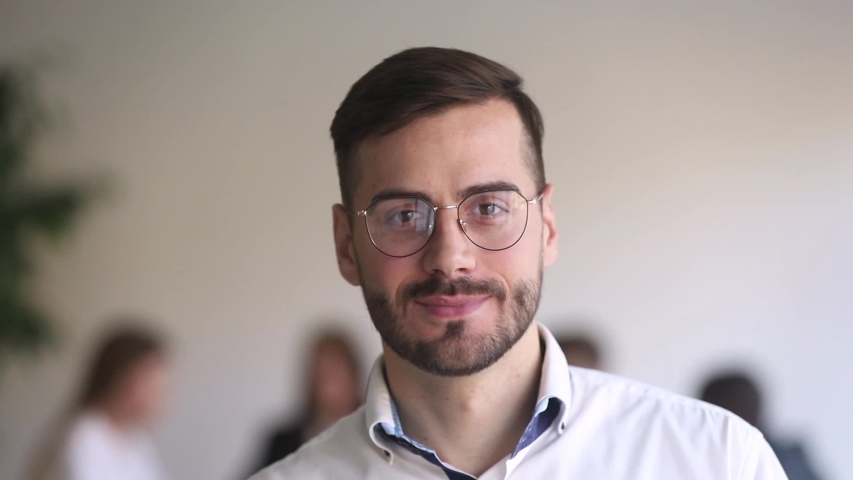 Head shot portrait leader of team handsome businessman in eyeglasses standing in office smile looking at camera. Motivation leadership, career growth, successful company member startup project concept | Shutterstock HD Video #1034756231
