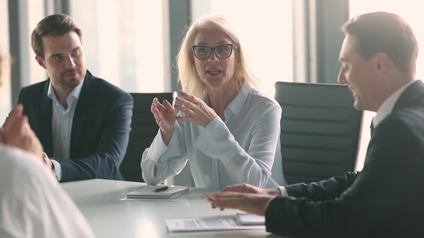 Business meeting lead by middle aged woman in modern boardroom, business parties company representatives meet for plan future collaboration, discuss terms conditions sign contract solve issues concept | Shutterstock HD Video #1034756330