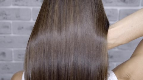 Result after lamination and hair straightening in a beauty salon for a girl with brown hair. hair care concept.