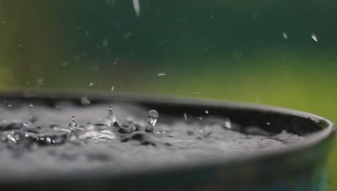 Raindrops falling on water surface. Heavy rain, splashes